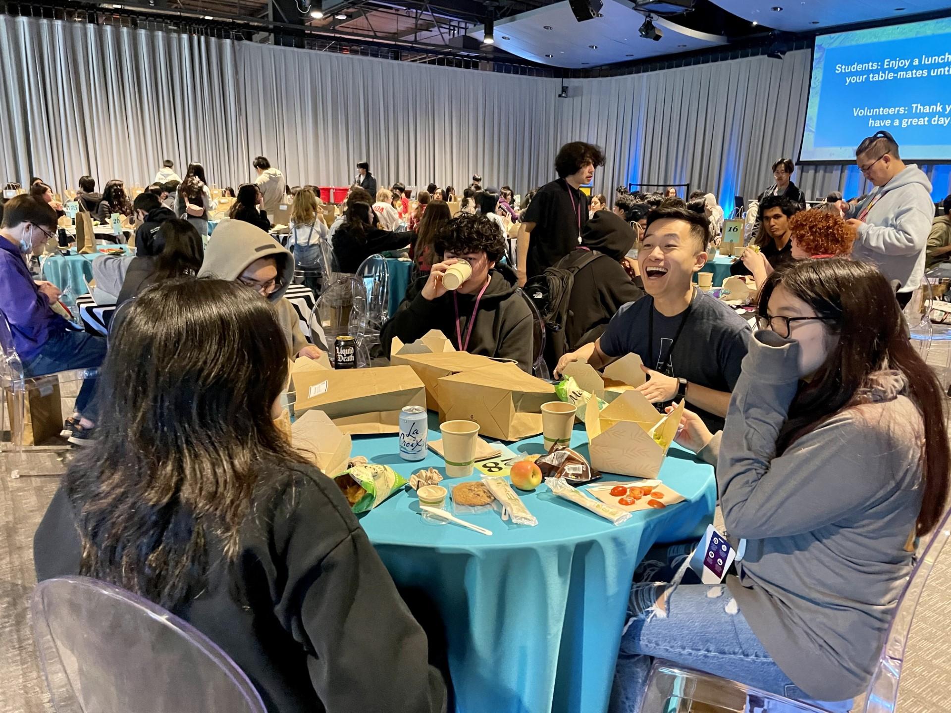South City High biotech teacher Rocky Ng (second from right) laughs it up with students during lunch at Genentech's Job Shadow Day on February 8, 2024.